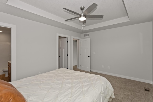 230 NW Waverly Dr, Waukee, IA 50263 - bedroom featuring a raised ceiling, baseboards, carpet flooring, ensuite bathroom, and a ceiling fan