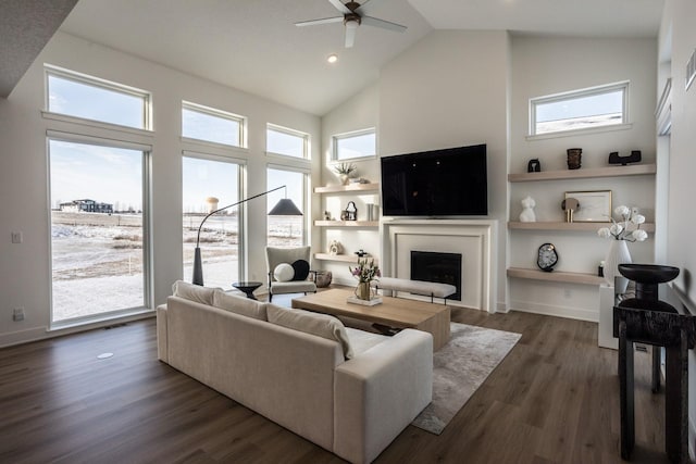 living room featuring high vaulted ceiling, ceiling fan, and dark wood-type flooring