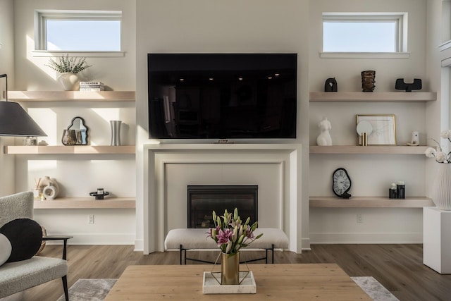 living room with built in shelves and wood-type flooring