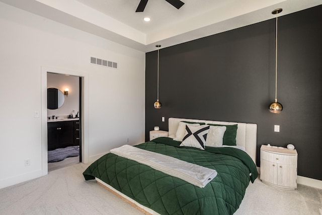 carpeted bedroom featuring ensuite bath, ceiling fan, and sink