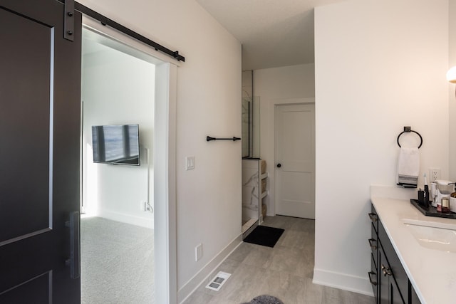 bathroom with vanity and a shower with door