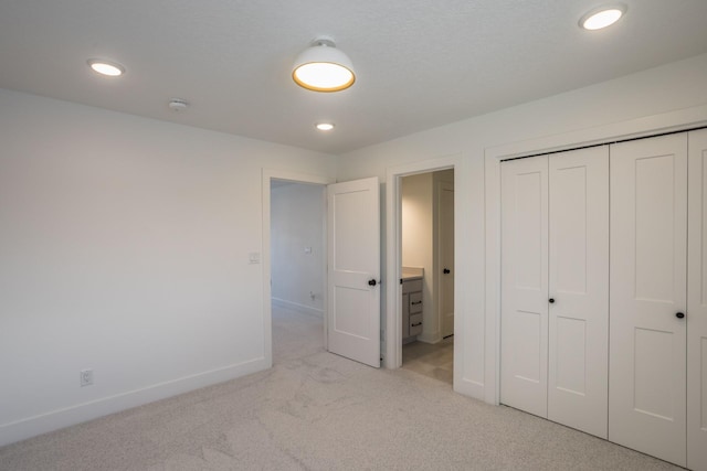 unfurnished bedroom with a closet and light colored carpet