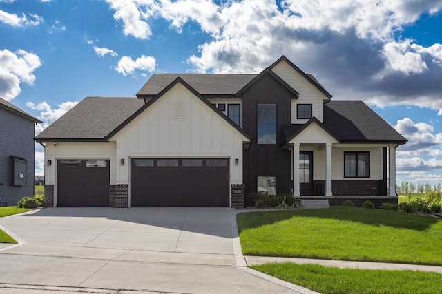 modern inspired farmhouse featuring an attached garage, a front yard, driveway, and brick siding