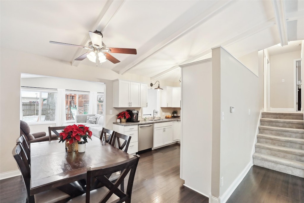 dining space with dark hardwood / wood-style flooring, ceiling fan, sink, and beamed ceiling