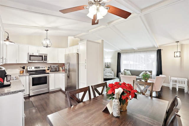 dining area with vaulted ceiling with beams, ceiling fan, and dark wood-type flooring