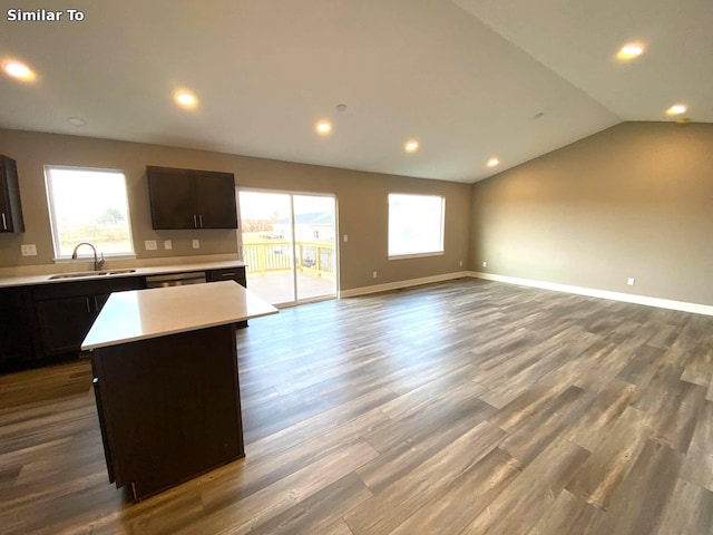 kitchen featuring a healthy amount of sunlight, sink, hardwood / wood-style floors, a center island, and lofted ceiling