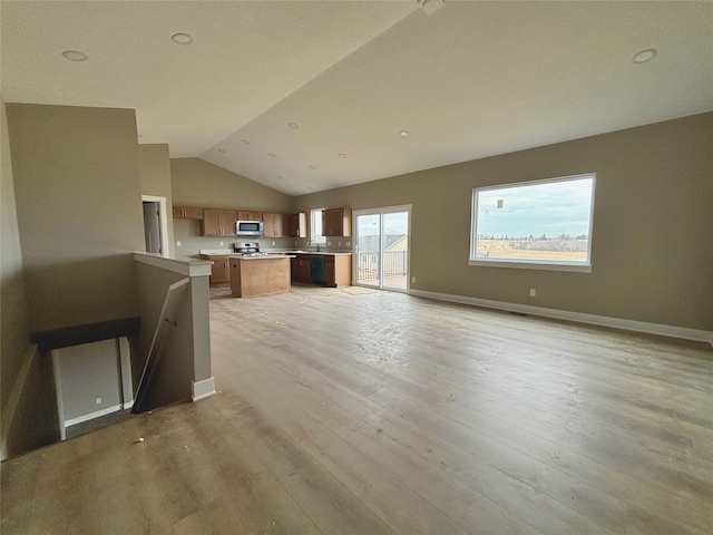 unfurnished living room featuring lofted ceiling, light wood finished floors, and baseboards