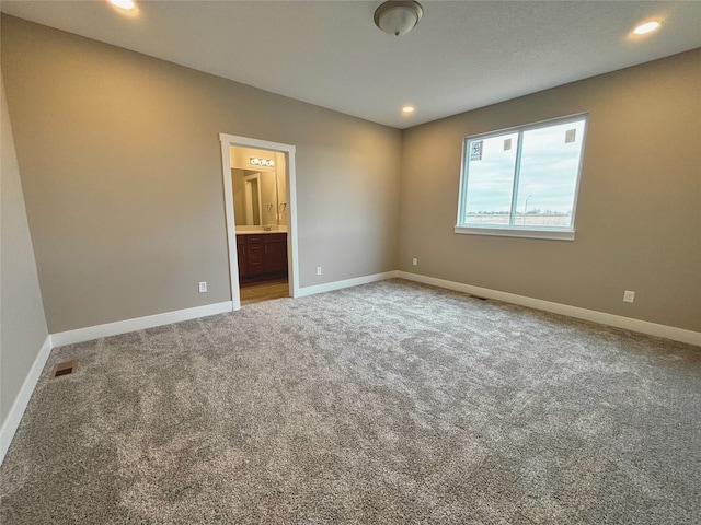 carpeted empty room featuring baseboards, visible vents, and recessed lighting