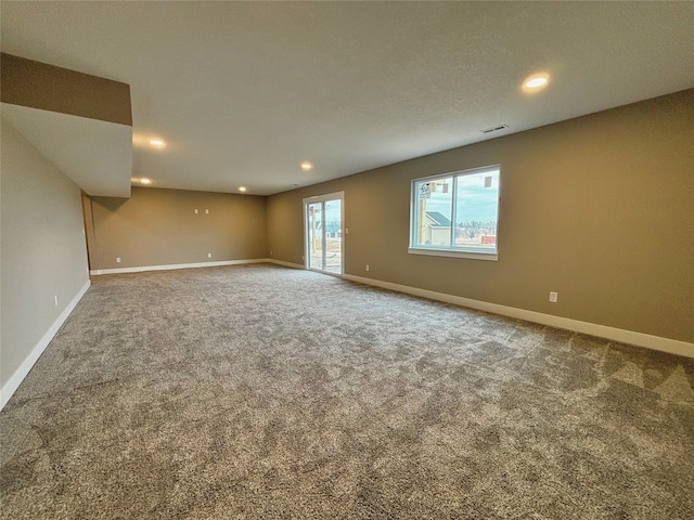 empty room featuring carpet floors, recessed lighting, visible vents, and baseboards