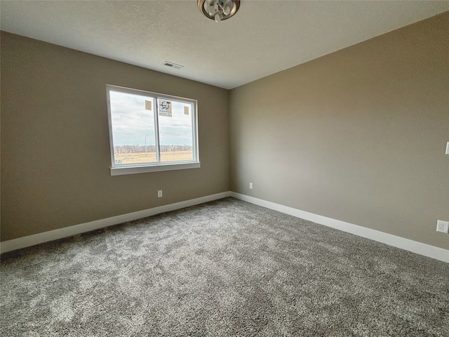 empty room featuring carpet floors, baseboards, visible vents, and a textured ceiling