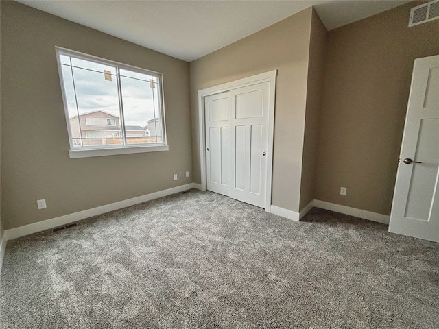 unfurnished bedroom featuring carpet, a closet, visible vents, and baseboards