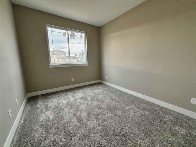 empty room featuring carpet floors and baseboards