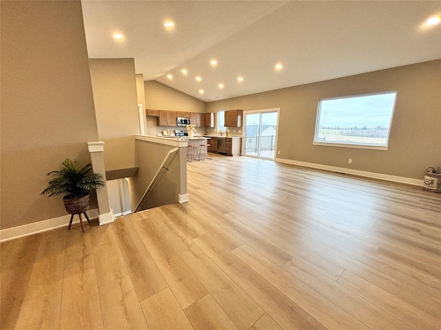 1677 20th Ave SE, Altoona, IA 50009 - unfurnished living room featuring light wood-type flooring, vaulted ceiling, baseboards, and recessed lighting