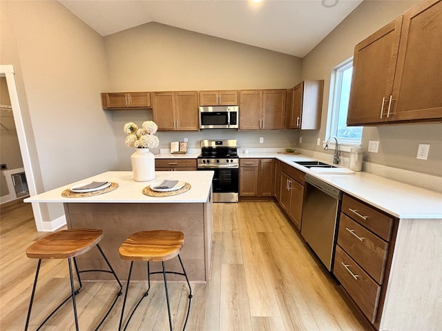 1677 20th Ave SE, Altoona, IA 50009 - kitchen featuring appliances with stainless steel finishes, a sink, a kitchen bar, light wood-type flooring, and light countertops