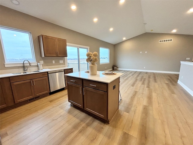 1677 20th Ave SE, Altoona, IA 50009 - kitchen featuring stainless steel dishwasher, a sink, light countertops, light wood finished floors, and vaulted ceiling