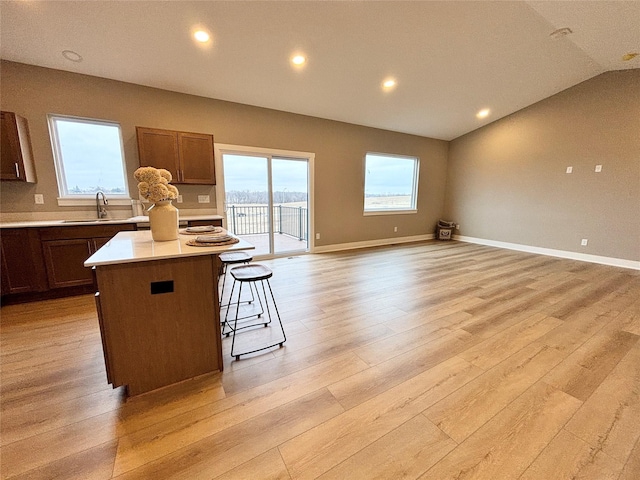 1677 20th Ave SE, Altoona, IA 50009 - kitchen with light wood finished floors, a sink, a center island, light countertops, and lofted ceiling