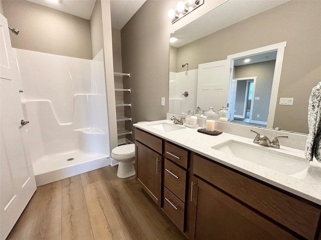 1677 20th Ave SE, Altoona, IA 50009 - full bathroom featuring a shower, wood finished floors, double vanity, and toilet