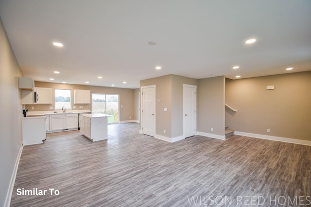 unfurnished living room featuring light wood-type flooring and sink