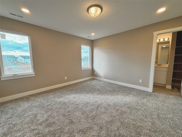 carpeted spare room with a textured ceiling, recessed lighting, visible vents, and baseboards