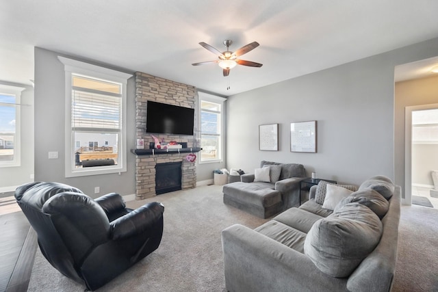 living room with ceiling fan, a healthy amount of sunlight, and a fireplace