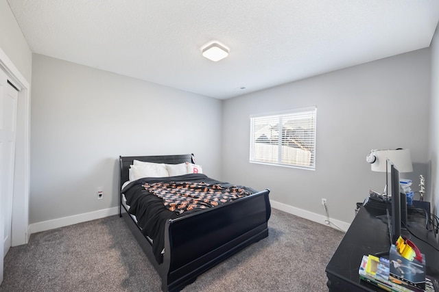 bedroom featuring a textured ceiling and dark carpet