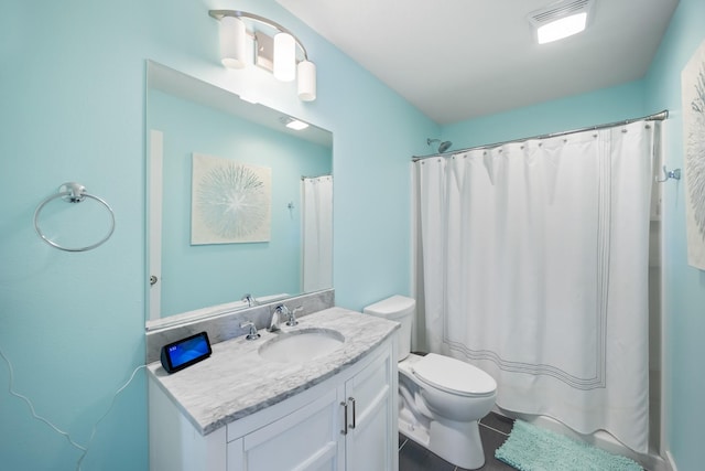 bathroom featuring toilet, vanity, tile patterned floors, and curtained shower