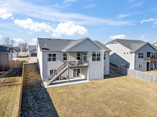 rear view of house with a patio area, a yard, and a wooden deck