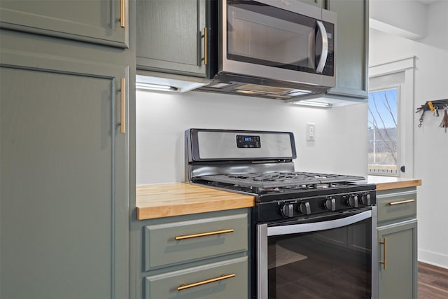 kitchen featuring butcher block counters, dark hardwood / wood-style floors, and appliances with stainless steel finishes