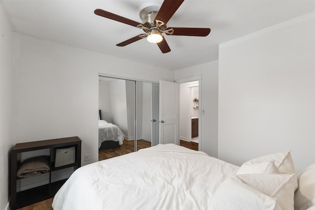 bedroom with dark wood-type flooring, ceiling fan, and a closet