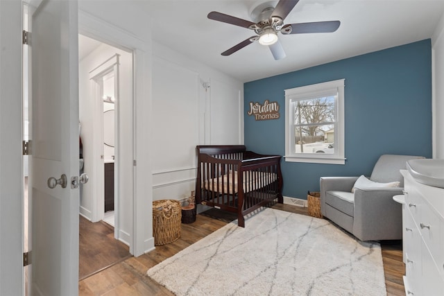 bedroom with ceiling fan, sink, light hardwood / wood-style floors, and a crib