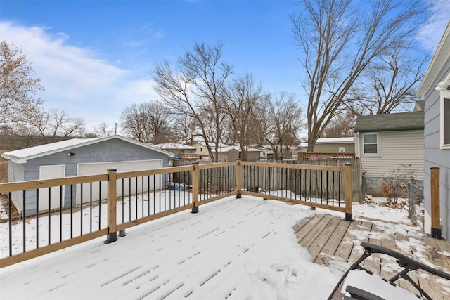 snow covered deck featuring an outbuilding and a garage