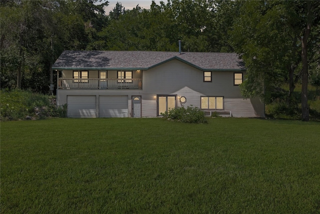 view of front facade featuring a garage, a balcony, and a front yard