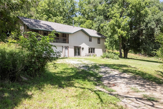 back of property featuring a garage and a lawn