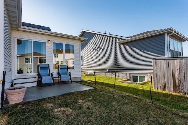 rear view of property with a lawn and a patio