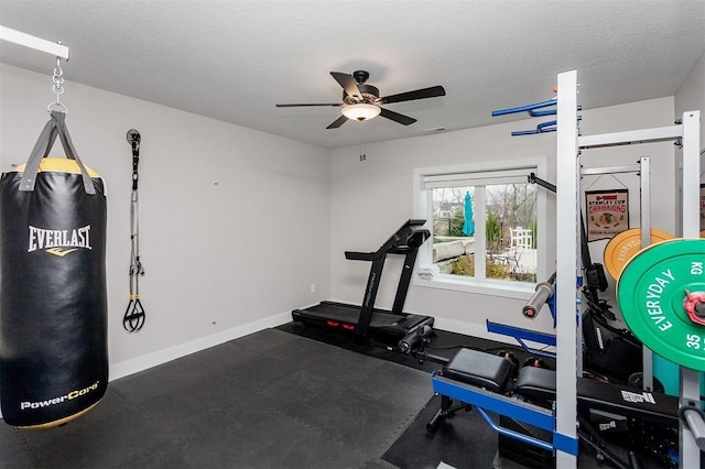 workout area featuring ceiling fan and a textured ceiling