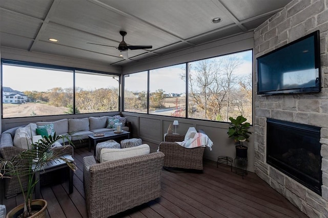 sunroom / solarium with ceiling fan, a fireplace, and coffered ceiling