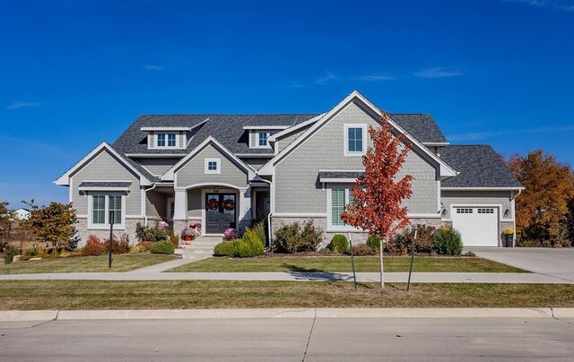 view of front of property featuring french doors, a garage, and a front lawn