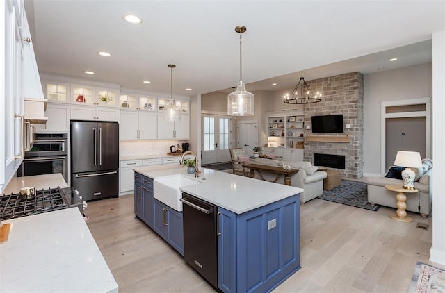 kitchen with sink, black dishwasher, high quality fridge, and white cabinets