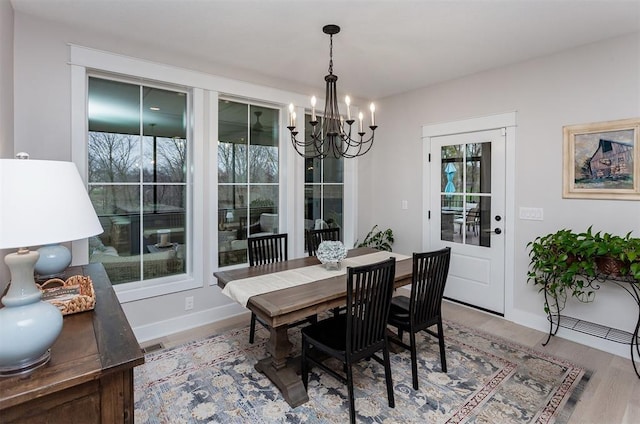 dining space featuring a healthy amount of sunlight, hardwood / wood-style floors, and a chandelier