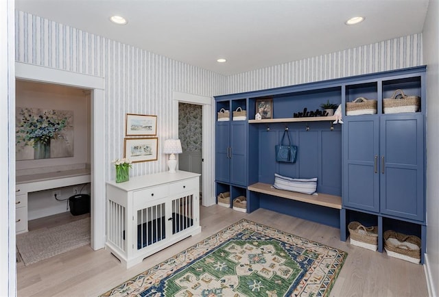 mudroom featuring built in desk and light hardwood / wood-style flooring