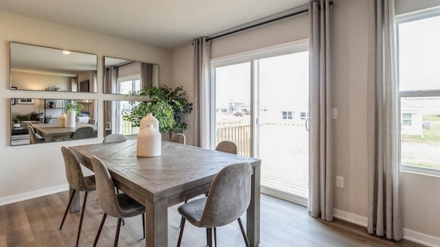 dining space featuring wood finished floors and baseboards