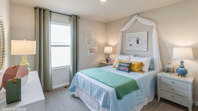 bedroom with carpet, multiple windows, and baseboards