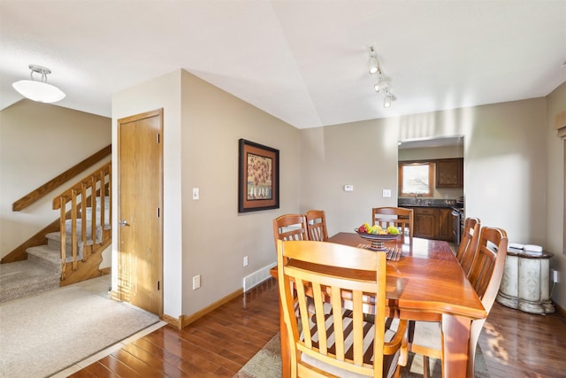 dining area with baseboards, visible vents, stairs, track lighting, and wood-type flooring