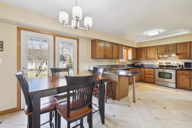 kitchen with kitchen peninsula, a breakfast bar, stainless steel appliances, an inviting chandelier, and hanging light fixtures