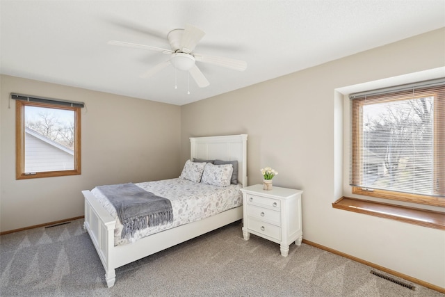 carpeted bedroom featuring baseboards, visible vents, and ceiling fan