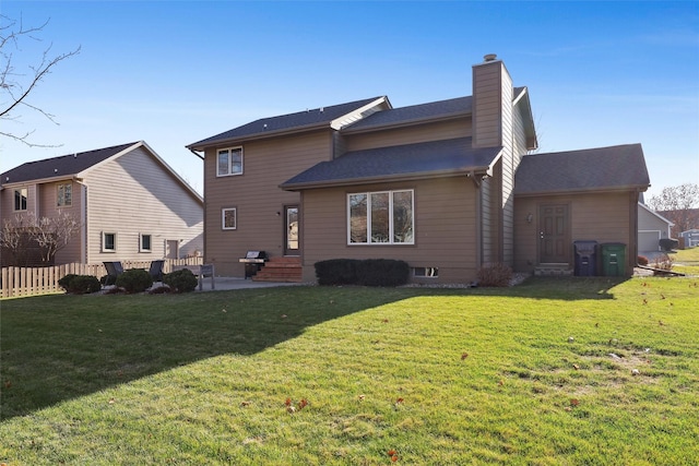 back of house featuring a yard, a patio, a chimney, and fence