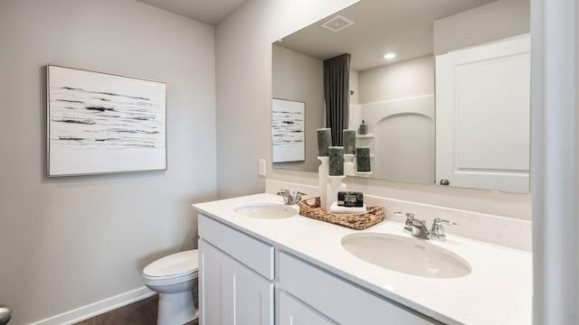 full bathroom with double vanity, visible vents, toilet, and a sink