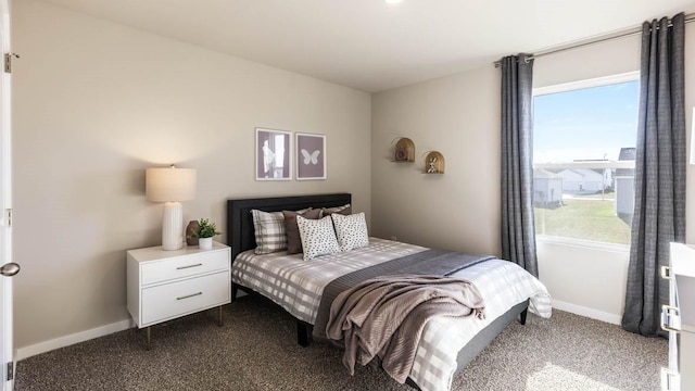 bedroom featuring dark carpet and baseboards