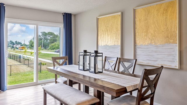 dining space featuring a textured ceiling and wood finished floors