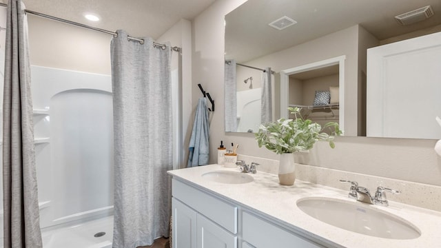 full bath with visible vents, a sink, and a shower stall